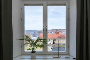 ein Fenster mit einer Topfpflanze davor in der Unterkunft Härnösands folkhögskolas Bed & Breakfast in Härnösand