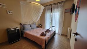 a bedroom with a bed with a canopy over it at Afytos Teo House in Kassandria