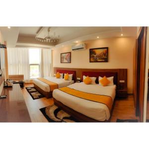 a hotel room with two beds with orange pillows at The Royal Bhumesh in Katra