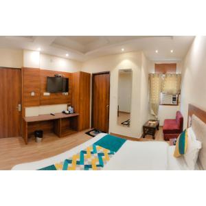 a hotel room with a bed and a tv at The Royal Bhumesh in Katra