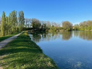 a path next to a body of water at Appartement dans joli village de vacances 47150 in Monflanquin