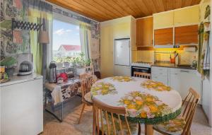 una cucina con tavolo e una cucina con tavolo e sedie di Amazing Home In Bergastrand With Kitchen a Berga Strand