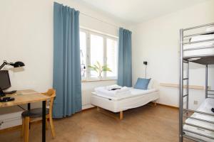Schlafzimmer mit einem Bett und einem Schreibtisch in der Unterkunft Härnösands folkhögskolas Bed & Breakfast in Härnösand