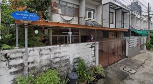 a building with a blue street sign in front of it at Smile Residence at Kaset-Sena in Ban Yang