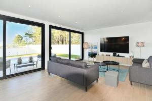 a living room with a couch and a tv at Moradia Sussurros do Mar in Nazaré
