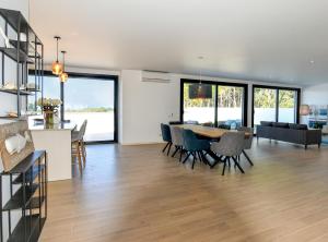 a dining room and living room with a table and chairs at Moradia Sussurros do Mar in Nazaré