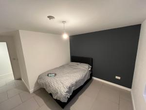 a bedroom with a bed and a black wall at Cozy two bed apartment in Clapham 1 in London