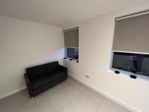 a living room with a black chair and a window at Cozy two bed apartment in Clapham 1 in London