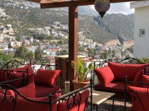 a balcony with red chairs and a view of a city at Villa Kirmizi Lale, Private Pool, Gardens, Very Close to Town - No Need for Taxi in Kas