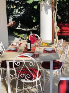 a white table with chairs and a bottle of wine at Villa Kirmizi Lale, Private Pool, Gardens, Very Close to Town - No Need for Taxi in Kas