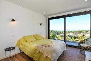 a bedroom with a bed and a large window at Moradia Sussurros do Mar in Nazaré +45 photos