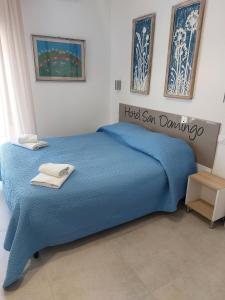 a blue bed in a bedroom with a sign on it at Hotel San Domingo in Lido di Camaiore