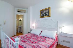 a bedroom with a white bed with a red blanket at Castelmola Casa Chiocciola with Terraces in Castelmola