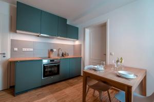 eine Küche mit blauen Schränken und einem Holztisch in der Unterkunft Ferienapartment Regensburg in Regensburg