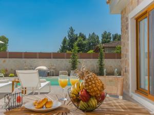 una mesa con un bol de fruta y copas de vino en Villa Terra - Laganas Stone Villas, en Laganas