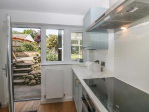 cocina con encimeras blancas y ventana grande en Ananda House, en Windermere
