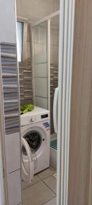 una lavatrice e asciugatrice in una piccola stanza con porta di Stay With Oleg C17 a Paralimni