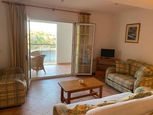 uma sala de estar com um sofá e uma mesa em HOSTAL RESTAURANTE CALA em Cala Figuera