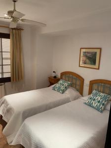 Duas camas sentadas uma ao lado da outra num quarto em HOSTAL RESTAURANTE CALA em Cala Figuera