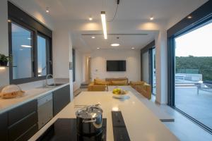 a kitchen and living room with a couch and a table at Villa Rona Lefkada in Sivota