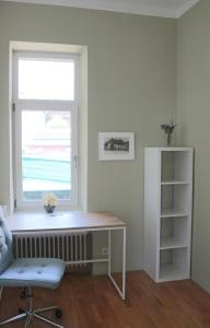 ein Fenster in einem Zimmer mit einem Schreibtisch und einem Stuhl in der Unterkunft Schöne einfache Wohnung in Jugendstilhaus in Feistritz an der Drau