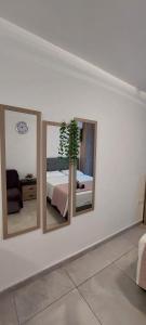 una camera da letto con tre specchi su una parete con un letto di Stay With Oleg C17 a Paralimni