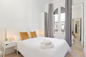 バルセロナにあるスイーツ4デイズ ガウディ アシャンプラの白いベッドルーム(白いベッド1台、鏡付)
