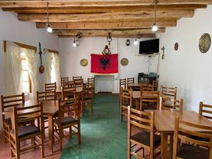 a room with wooden tables and chairs and a flag at Villa Belinis in Theth