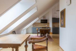 an attic dining room with a table and chairs at Hotel Freischütz Apartments in Landshut