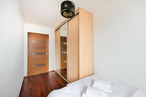 a bedroom with a bed and a large mirror at Park Mirowski Standard Apartment in Warsaw