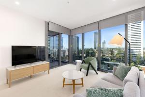 a living room with a couch and a tv at ULTIQA Signature at Broadbeach in Gold Coast