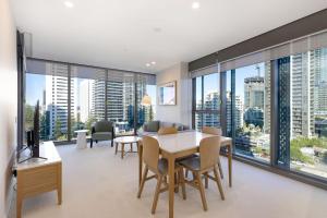 a living room with a table and chairs and a large window at ULTIQA Signature at Broadbeach in Gold Coast