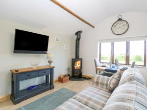 a living room with a fireplace and a flat screen tv at The Annexe, Grange Farm in Norwich