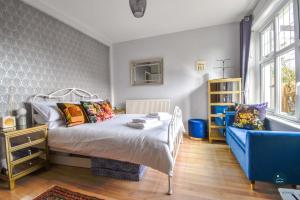 a bedroom with a bed and a blue chair at Bowleaze Hideaway - beachside dog friendly in Weymouth