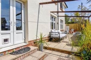 a patio with a white door and a chair at Bowleaze Hideaway - beachside dog friendly in Weymouth