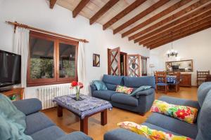 sala de estar con sofás azules y TV en Villa Porqueres, en Pollensa