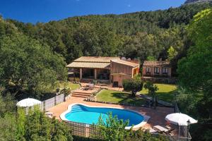 a home with a swimming pool and a house at Villa Porqueres in Pollença