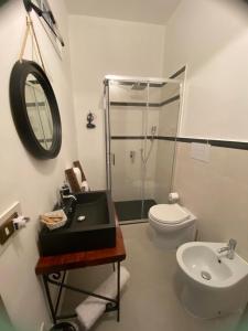 a bathroom with a sink and a toilet and a mirror at Domus Petra in Rocca Cilento
