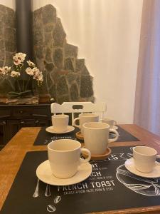 einen Tisch mit Tassen und Untertassen darüber in der Unterkunft Domus Petra in Rocca Cilento
