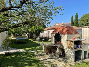 a backyard with an outdoor grill and a table at Belle maison 140 m2 à 15 mn de la mer Montpellier in Teyran