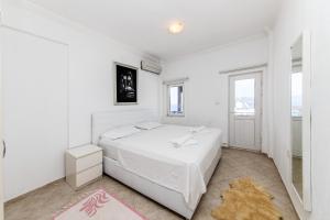 a white bedroom with a bed and a mirror at Sea View Duplex Private Villa in Bodrum Gundogan in Gundogan