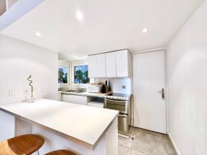 une cuisine avec des placards blancs et un comptoir blanc dans l'établissement Èrsextius ABB Aix-en-Provence, à Aix-en-Provence