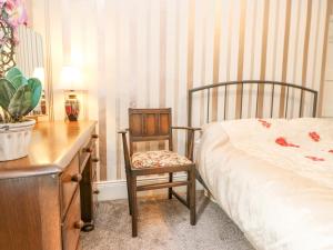 ein Schlafzimmer mit einem Bett, einem Stuhl und einem Schreibtisch in der Unterkunft 3 Tindale Terrace in Brampton