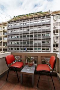 a balcony with two chairs and a table and a building at Charlie city center room in Athens