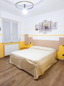 a bedroom with a large bed with yellow walls at BIKE HOUSE 4 "beach" in Seriate