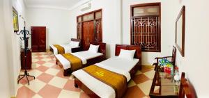 Duas camas num quarto com piso em xadrez em Nhà nghỉ Xuân Long - Xuan Long gues - Tỉnh Điện Biên em Ban Hin Lom