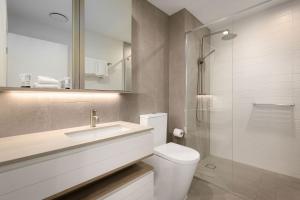 a bathroom with a toilet and a sink and a shower at ULTIQA Signature at Broadbeach in Gold Coast
