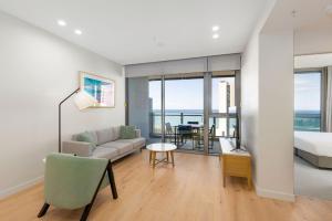 a living room with a couch and a bed at ULTIQA Signature at Broadbeach in Gold Coast