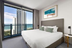 a bedroom with a large bed and a large window at ULTIQA Signature at Broadbeach in Gold Coast