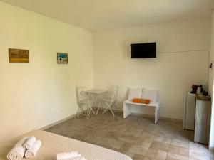 a bedroom with a table and a tv on the wall at B&B La Pintadera in Santa Teresa Gallura